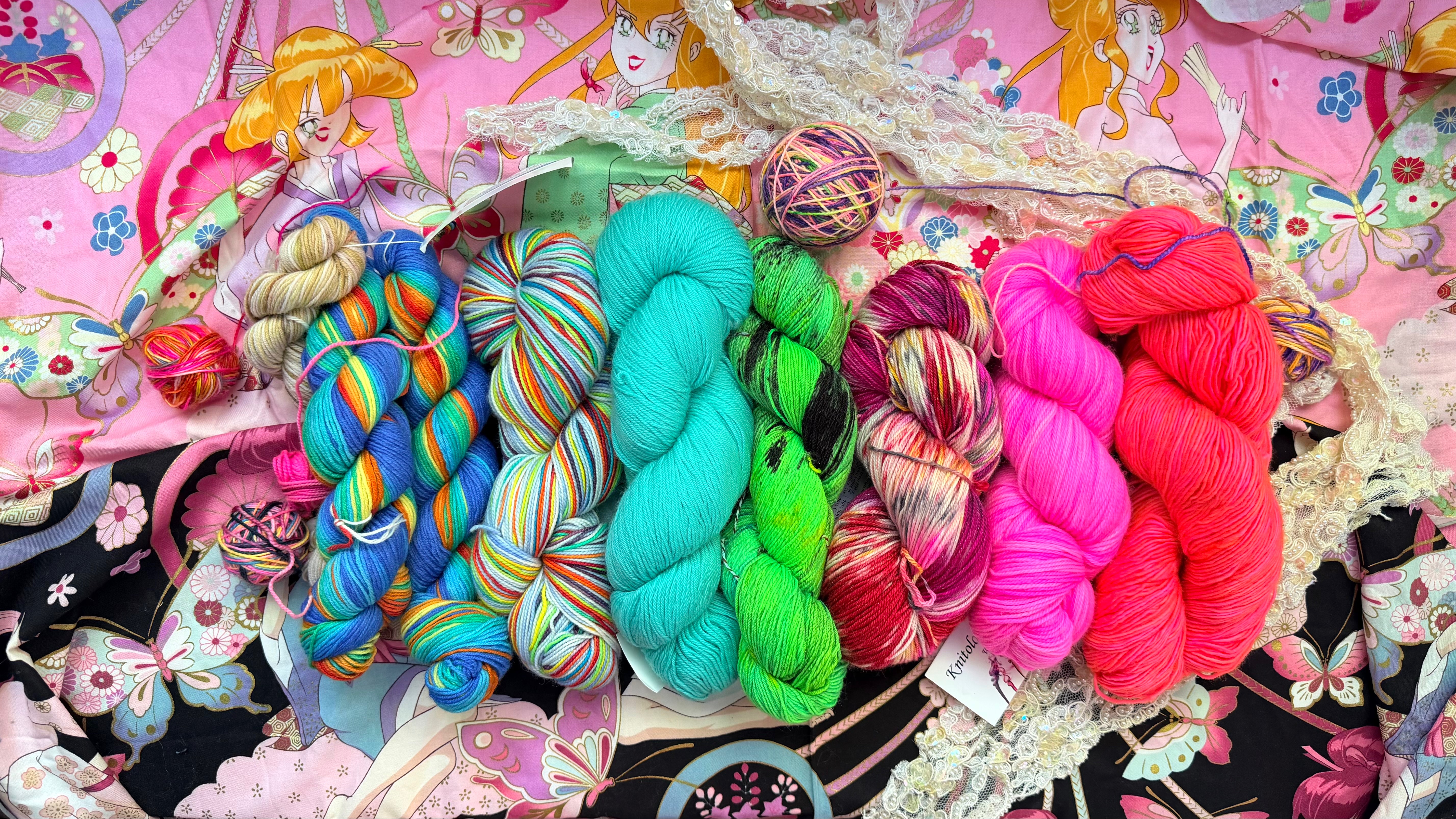 Storybook Yarn — bright painterly arrangement of skeins on a dark surface
